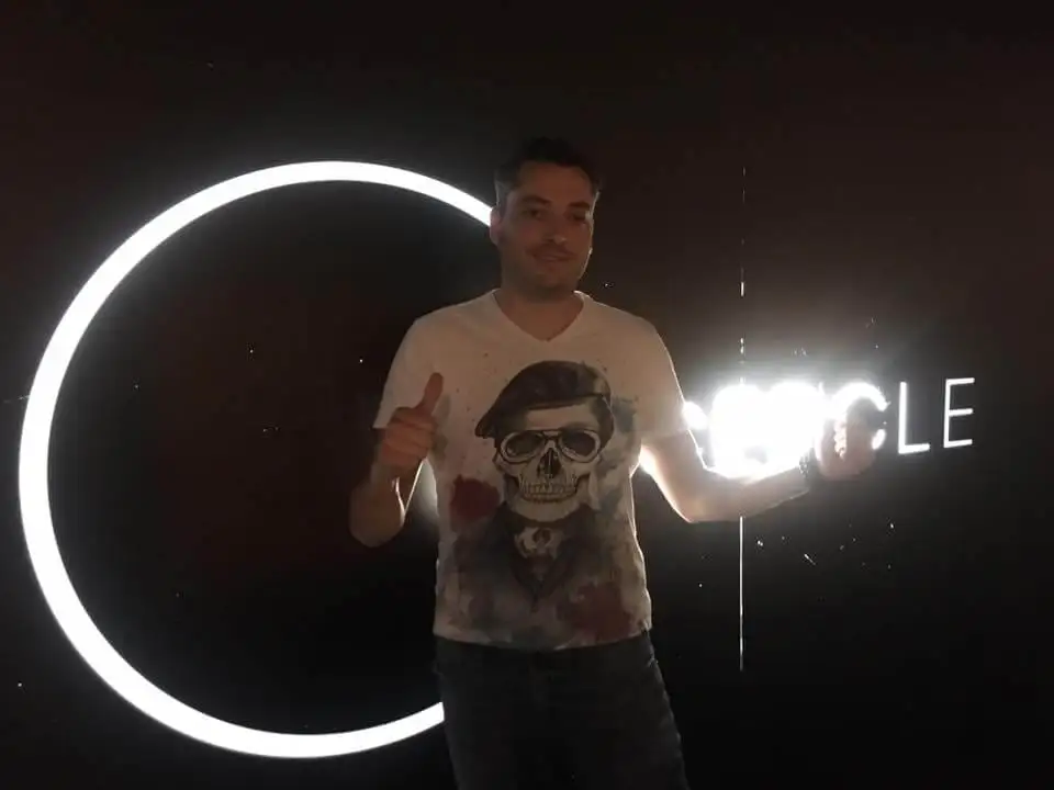 Invité posant devant un cercle lumineux installé pour la soirée
