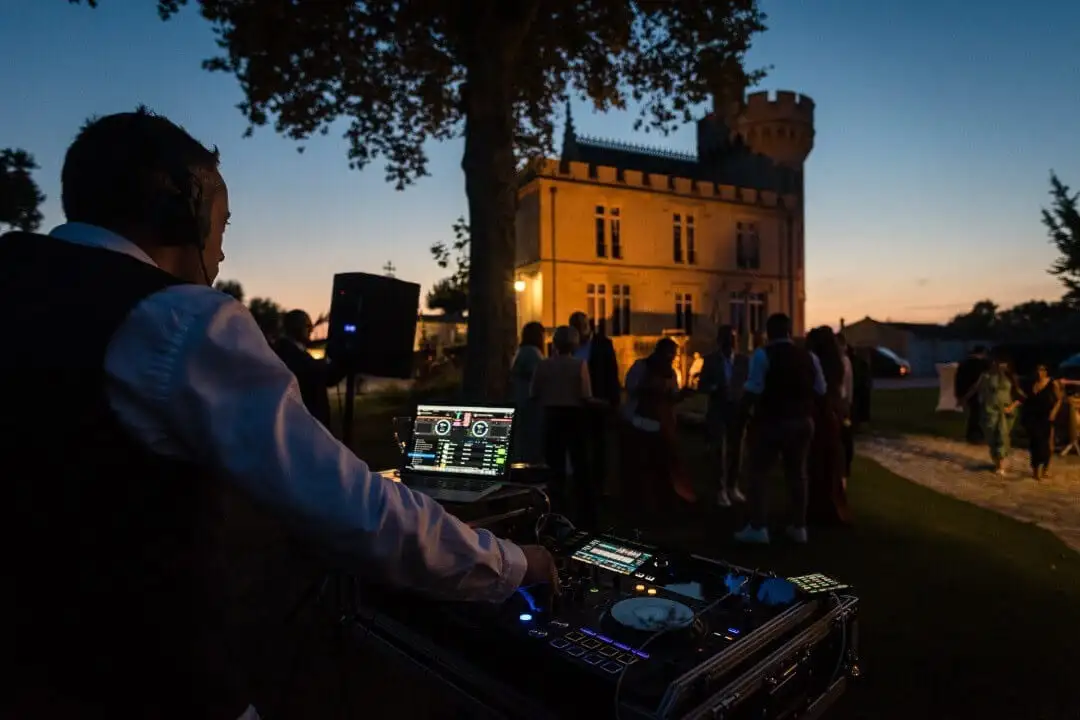 Tom Emersson aux platines en extérieur, château en arrière-plan au coucher du soleil