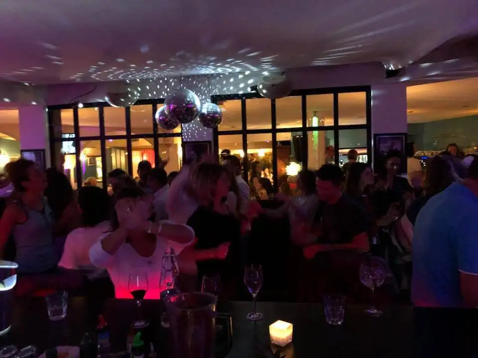 Convives attablés lors d’une soirée, boule à facettes au plafond
